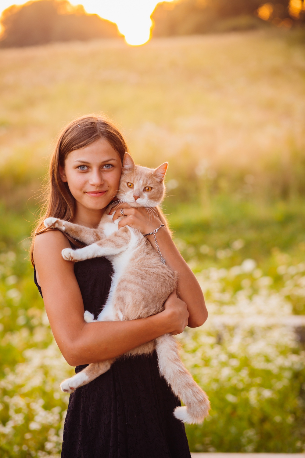 women hold a cat standing on the field